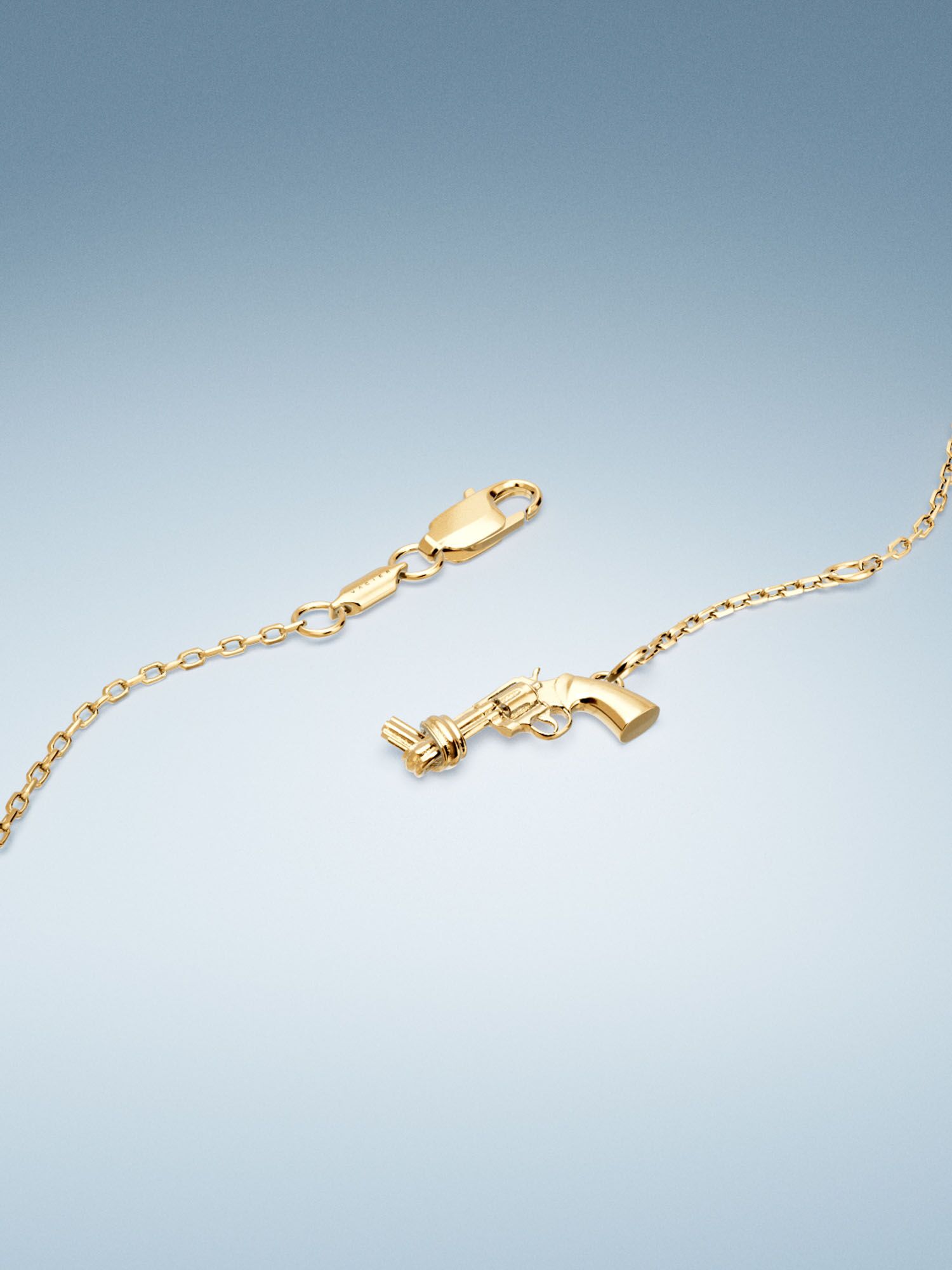 Vacier Chain Bracelet Gold for Women with the Non-Violence Knotted Gun pendant close up view