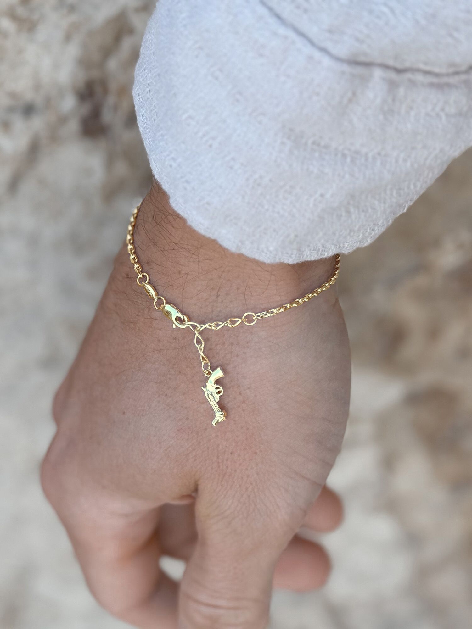 Vacier Chain Bracelet Gold for Men with the Non-Violence Knotted Gun pendant on a model